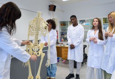 Medical students studying human skeleton in laboratory Medical students studying human skeleton in laboratory
