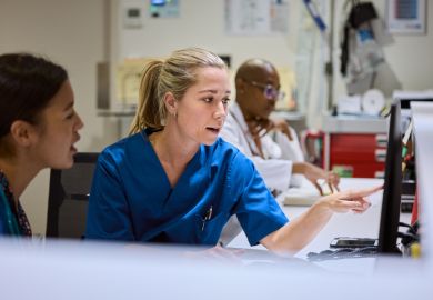 Nurses using computer at desk in hospital 