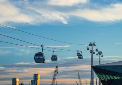 Modern Cable Car System Soaring Above the City Skyline at Sunset in Greenwich, London Modern Cable Car System Soaring Above the City Skyline at Sunset in Greenwich, London