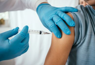 Doctor administering vaccine to teenager in doctor's office Doctor administering vaccine to teenager in doctor's office