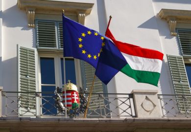 Hungary and EU flags perched outside a balcony