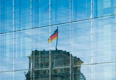 A reflection of the german flag on top of the Reichstag building on a glass facade 