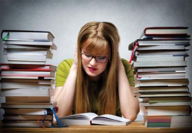 Girl studying surrounded by books
