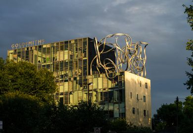 Goldsmiths, University of London, in New Cross, London bathed in dramatic yellow sunlight with a cloudy sky.