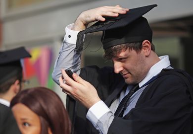 Students adjust their caps ahead of their graduation ceremony, London, UK. To illustrate that over half of graduates regret their undergraduate decisions 