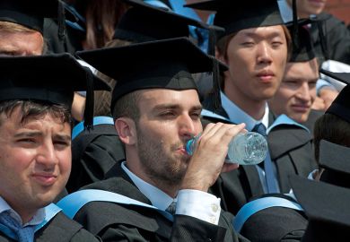 A graduation ceremony with a graduate drinking water and looking hot, UK. To illustrate that dealing with extreme heat is ‘hugely problematic’ for universities. A graduation ceremony with a graduate drinking water and looking hot, UK. To illustrate that dealing with extreme heat is ‘hugely problematic’ for universities.