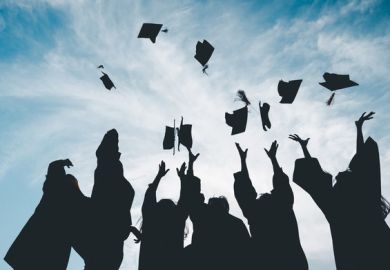 Graduates throw their caps into the air, symbolising the graduate premium