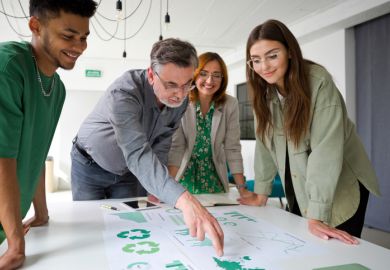 A businessman points at a chart while brainstorming with colleagues, symbolising green business expertise 