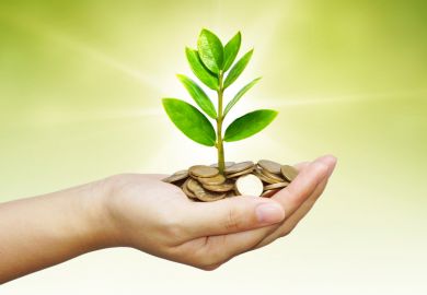 Hand holding growing pile of money (economic growth)