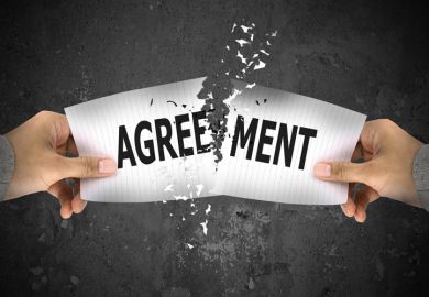 Hands ripping up paper agreement