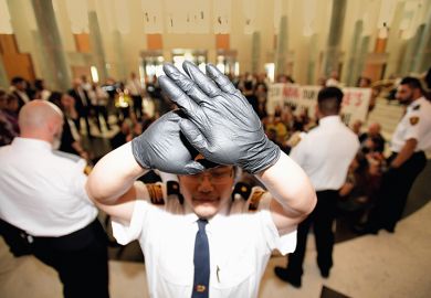 Security guard holds up hands