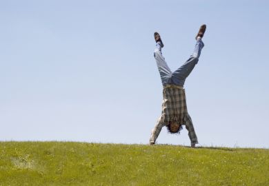 Student handstand on grass
