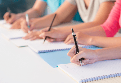 Students writing by hand Students writing by hand