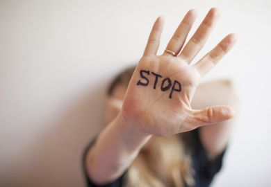 A woman with "stop" written on her palm A woman with "stop" written on her palm, symbolising harassment