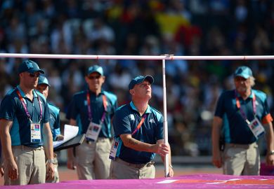 An official is setting the bar during the women's high jump at the London 2012 Olympic Games, illustrating that the UK government is expected to resist pressure to set an ambitious new target for international student numbers.