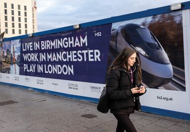 A woman walks in front of a billboard advertising HS2