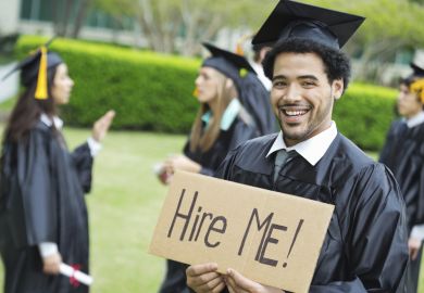 Graduate holding hire me sign