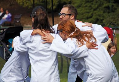 people wearing lab coats huddling together people wearing lab coats huddling together