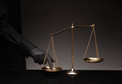 A man presses his finger on the scales of justice
