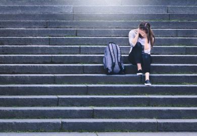 An upset woman sits alone on some steps