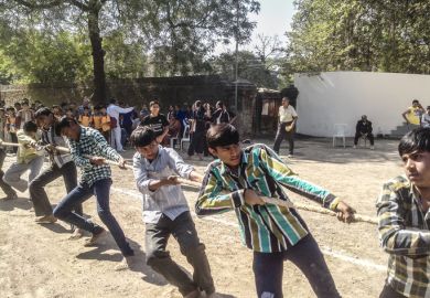 Young teenagers playing The game Tug of the war during Khel Maha Kumbh.