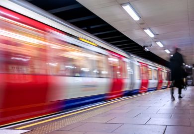 A London Underground train speeds through a station. Lack of commute is a factor in academics reporting satisfaction with homeworking.