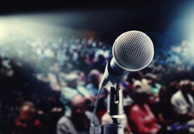 View from behind a microphone of a crowded meeting room
