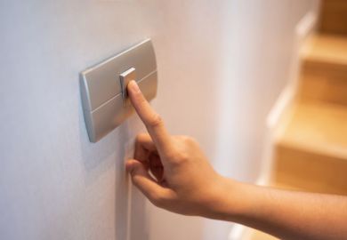 Closeup of finger is turning on or off on light switch at the house