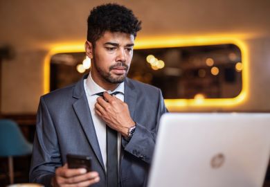 A candidate adjusts his tie before a job interview. Online interviews add an extra layer of difficulty to an already stressful situation.
