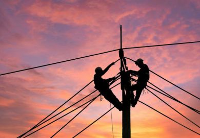 Electrician climbing electric power pole to repair damaged power cable line