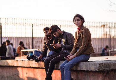 Group of students sitting in a campus Group of young male and female students sitting inside the university campus of Jamia Millia Islamia entrance door.