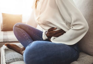 A woman clutches her stomach because of period pain
