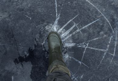 Fisherman foot on broken cracked thin ice at lake Fisherman foot on broken cracked thin ice at lake