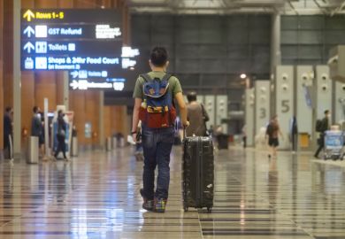  A man wheels a suitcase towards check-in counters at the departure hall of Terminal 3, Changi Airport.