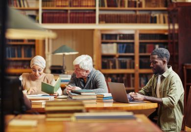 Several people studying in a library Several people studying in a library