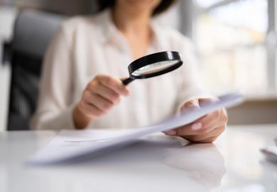 Woman looks at document with magnifying glass