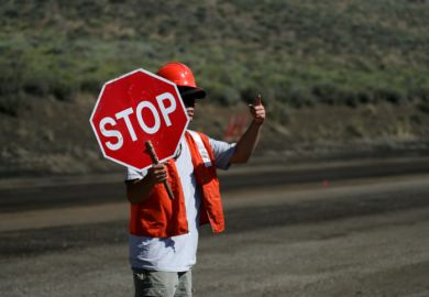 A man holds a 'stop' sign A man holds a 'stop' sign
