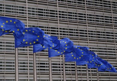 Blue flags flap in the wind outside EU headquarters