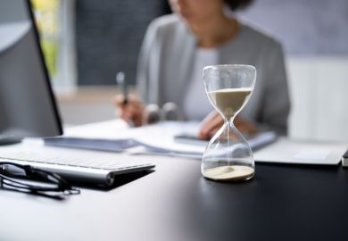 Hourglass on desk running out Hourglass on desk running out