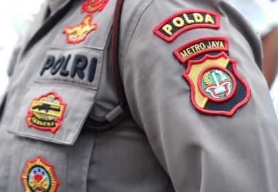 The arm of an Indonesia police officer, with badges