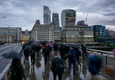 People cross a London bridge in the rain People cross a London bridge in the rain