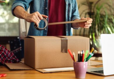 A man puts some tape onto a cardboard package