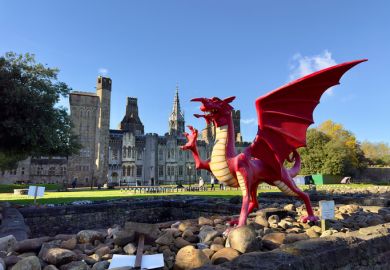 A red dragon in front of the Cardiff Castle and Victorian Gothic revival mansion in Cardiff, Wales.