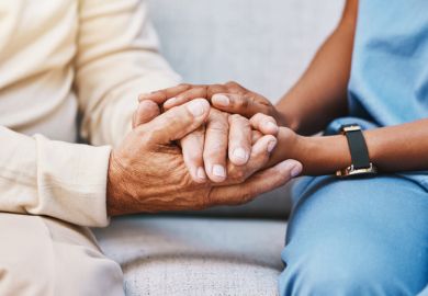 Close-up of carer holding hands with someone