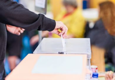 Person putting polling card in ballot box