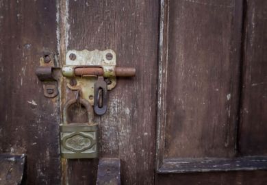 Unlocked padlock on wooden door