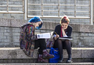 Two young female students studying outdoors.