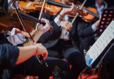 Violins playing in an orchestra Violins playing in an orchestra