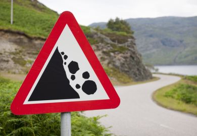 Signing warning that boulders may fall down on the road ahead