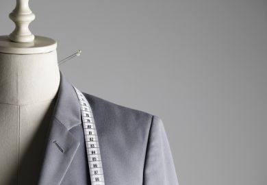 Suit jacket on tailor's mannequin with pins and tape measure